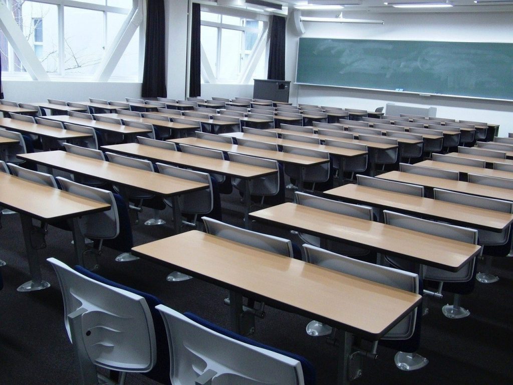 教育学部の教室に黒板と、机といすが並んでいる